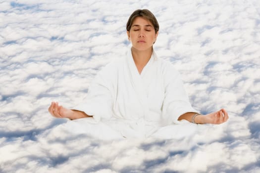 Mid adult woman practicing yoga on clouds