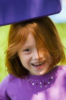 Portrait of a girl carrying a cushion on her head and smiling