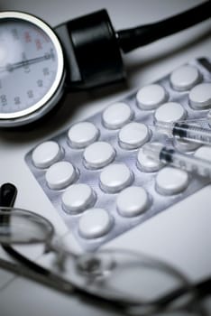 Close_up of eyeglasses and pills with medical equipments