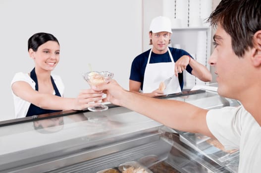 Female ice cream seller giving ice cream to a customer