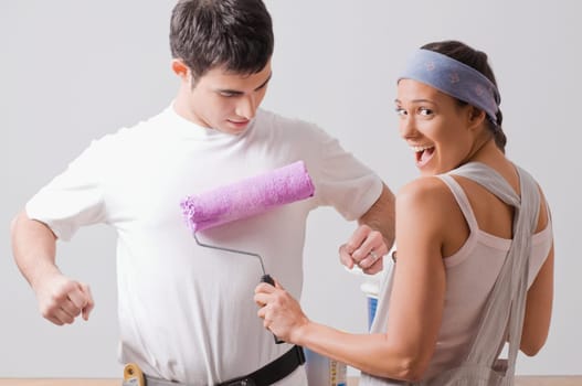 Portrait of a young woman painting on a young manŽs t_shirt and smiling