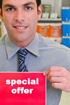 Sales clerk showing a Special Offer sign