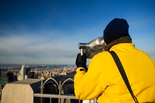 Rear view of a person looking through a coin_operated binocular, Manhattan, New York City, New York State, USA