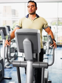 Mid adult man exercising on a treadmill in a gym