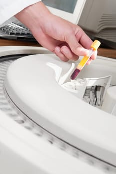 Lab technician putting a blood sample in the laboratory freezer