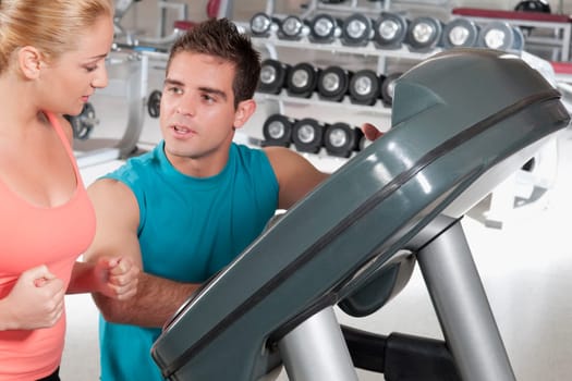 Man assisting a woman on a treadmill