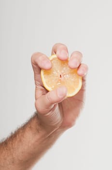 ManŽs hand squeezing an orange half