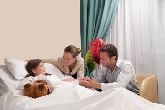 Parents with their daughter in a hospital ward