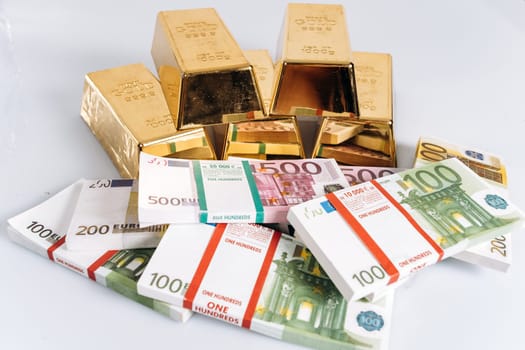 Gold bullions at euro banknotes closeup background. Gold bars lie on Euro banknotes