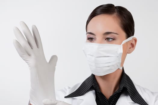 Female doctor putting on surgical gloves