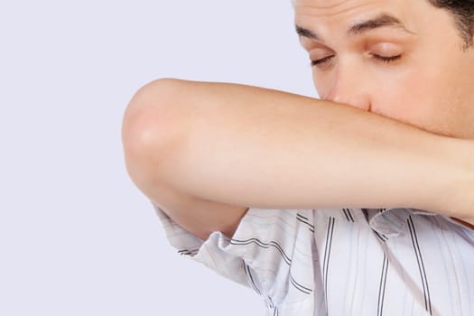 Man rubbing his nose with arm