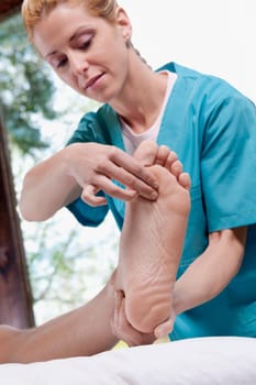 Physiotherapist examining the foot of a patient