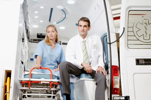 Doctor sitting with a female nurse in an ambulance
