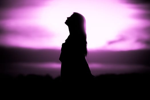 Silhouette in front of sunset or sunrise in summer nature. Symbol for healing burnout therapy, wellness relaxation or resurrection.