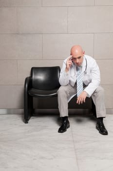 Doctor sitting on a chair and looking stressed