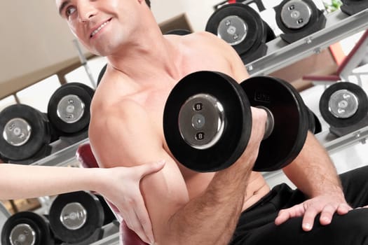 Man exercising with dumbbells in a gym