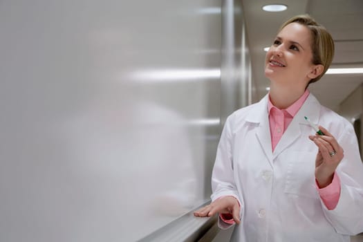 Female doctor writing on a whiteboard in a hospital