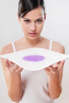Portrait of a woman holding a tray of bath crystals