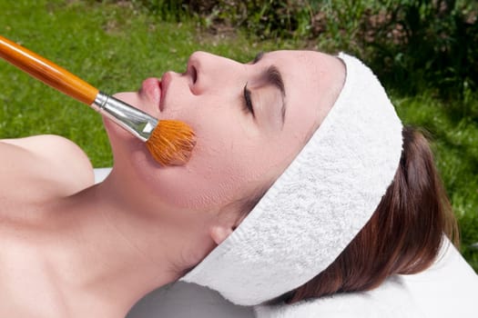Woman applying a facial mask