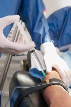 Doctor injecting patientŽs arm in an operating room
