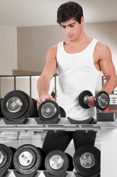 Man picking up dumbbells in a gym