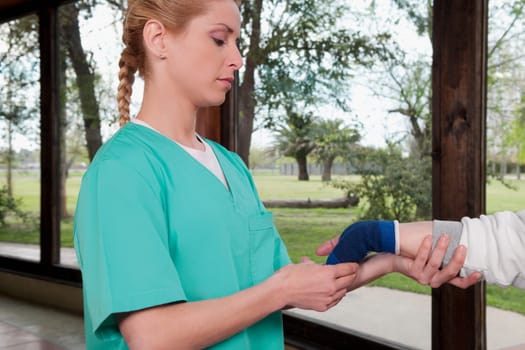 Health worker putting on a wrist brace to a disabled person