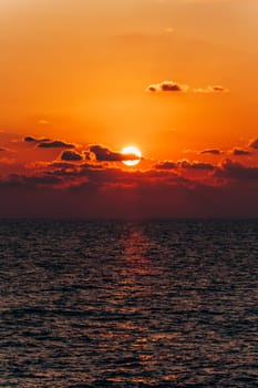 Beautiful sunset over the sea. Reflection of sunset in the sea. Orange sunset.