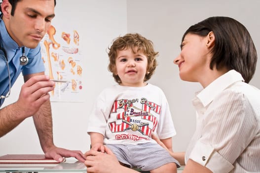 Doctor reading a baby boyŽs temperature sitting with his mother