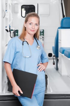 Female nurse standing in front of an ambulance