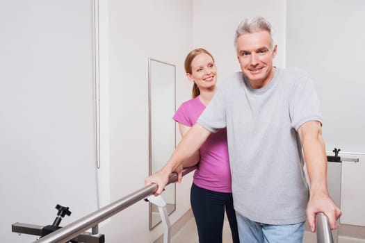 Physiotherapist assisting a patient in walking