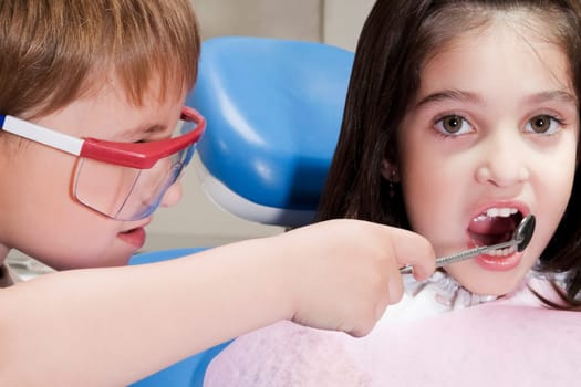 Boy imitating as a dentist and examining a girlŽs teeth