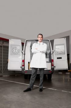 Doctor standing with an ambulance behind him