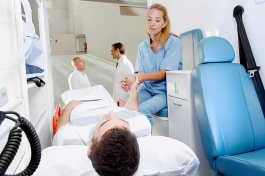 Female nurse consoling a patient lying on gurney