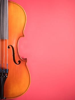 Detail of a violin against a coloured background
