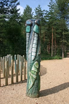 A total pole with a cricket and flies in the forest