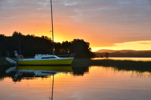 yellow sailing boat in sunset