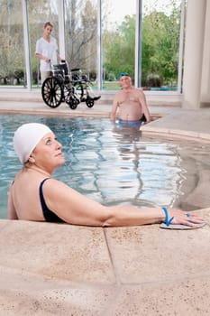 Woman wearing swim paddles in a swimming pool