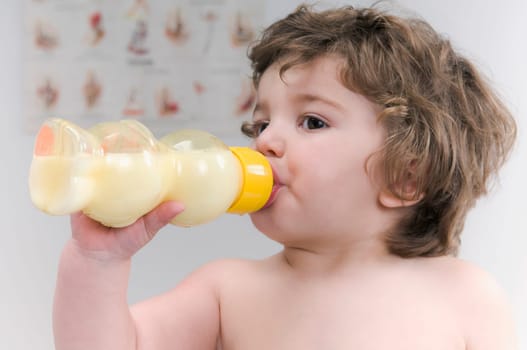 Baby boy drinking milk from a baby bottle