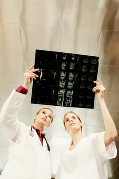Female doctor and a nurse examining an X_Ray