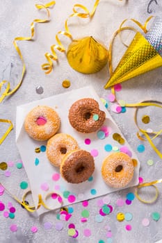 Donuts for carnival and party. Donuts with streamers and confetti. Colorful carnival or birthday image.