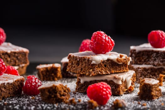 Homemade vegan chocolate brownies with nuts, lemon icing and raspberries