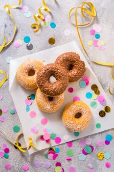 Donuts for carnival and party. Donuts with streamers and confetti. Colorful carnival or birthday image.