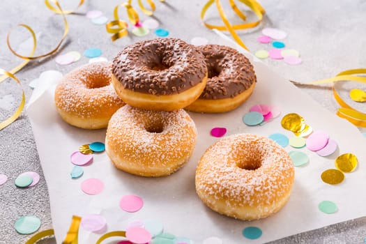 Donuts for carnival and party. Donuts with streamers and confetti. Colorful carnival or birthday image.
