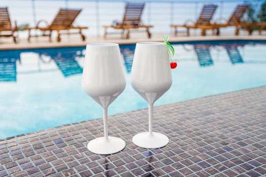 Two  Cocktails near the Swimming Pool on the Background. Exotic Summer Vacation