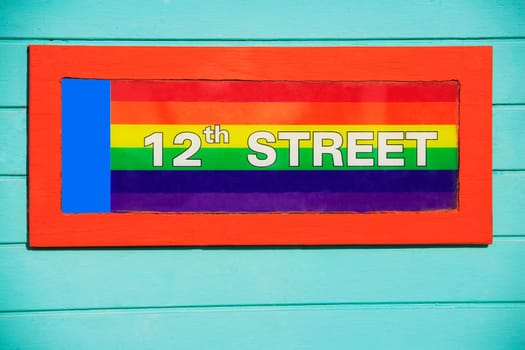 Close_up of a colorful signboard on a gay flag background, 12Th Street, Miami Beach, Florida, USA
