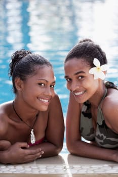 Portrait of two female friends smiling in a swimming pool