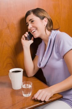 Young woman talking on a mobile phone in a cafe
