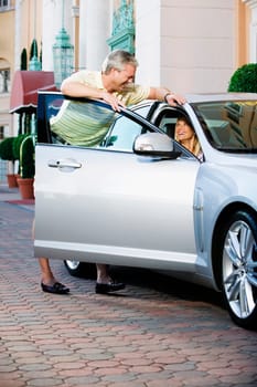 Man looking at his wife sitting in a car and smiling, Biltmore Hotel, Coral Gables, Florida, USA