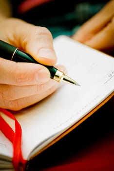 Close_up of a personŽs hand writing on a diary