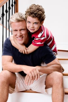 Boy hugging his father on a staircase